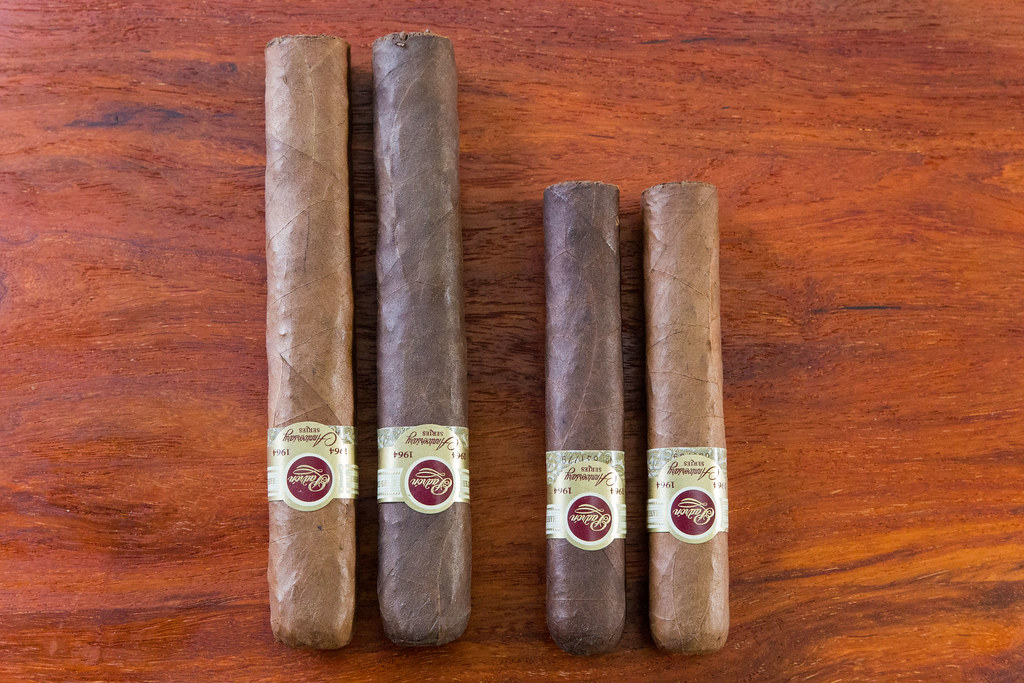 Four premium cigars laid side by side on a wooden table